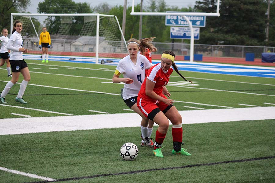 Shawnee Heights thunder bird defends the ball against Sophomore, Laura Campbell.