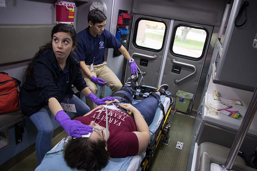 Two students tend to one of the injured patients from the simulated car crash.