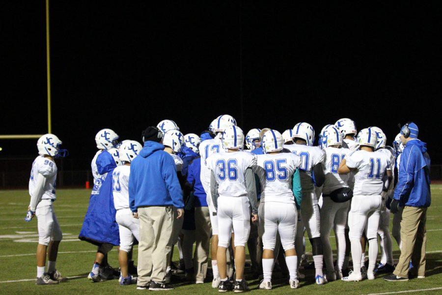 Junction City Blue Jays football team in a huddle during a timeout. 