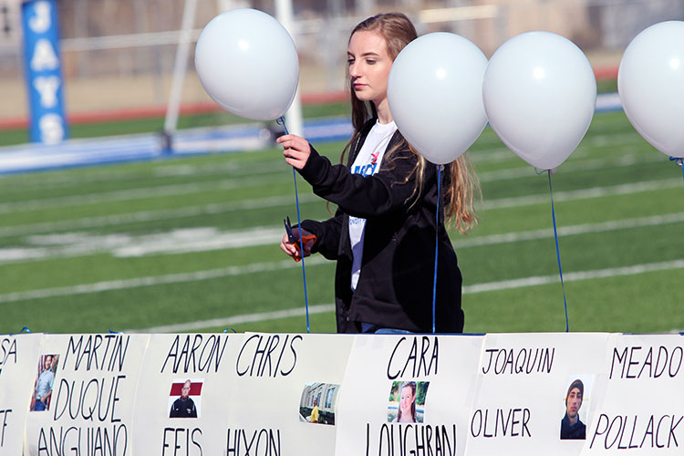 Sidney Budinas releases a balloon in honor of Chris Hixon, one of the victims in the Parkland FL school shooting.