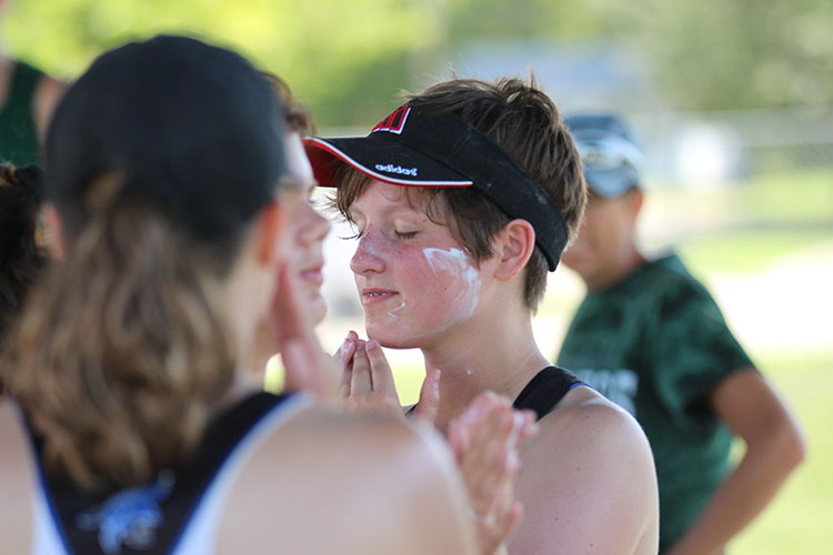 Freshman Avery Jacobsen rubs sunblock on her face prior to a the JC quadrangular on August 30.  