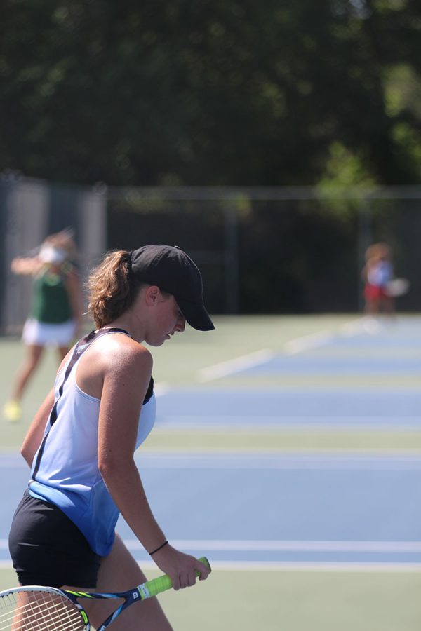 Sophomore Morgan Carroll returns to the court after retrieving lost balls at a tennis match on August 30.