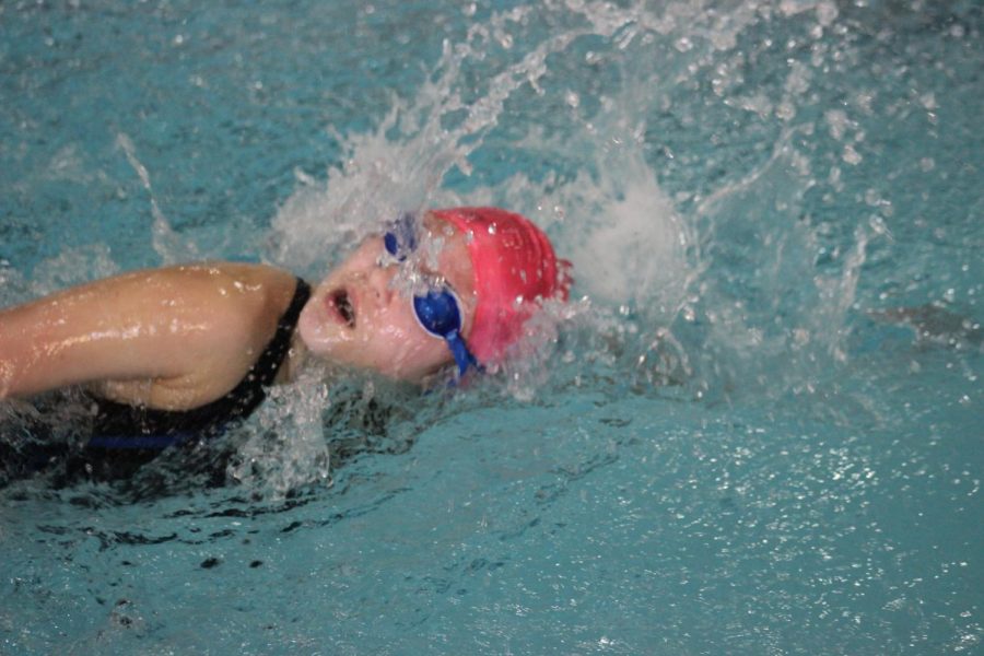 One of the swim team members swims free style. 