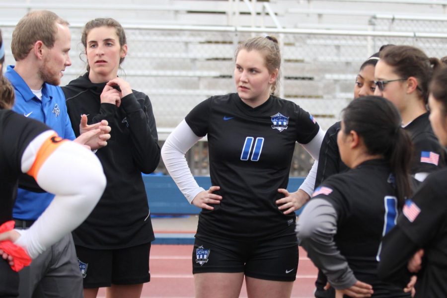 Senior Maja  Bellika (center) listens to head coach Mitchell Dehoff before a game. Bellika scored the game wining goal to end double overtime against Wichita West on March 28.