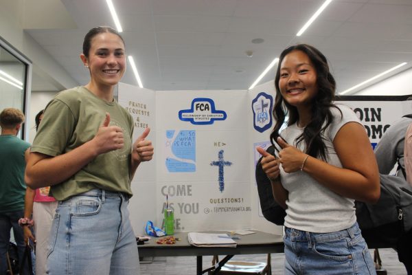 JCHS held an activities fair at the start of the school year. Seniors Cassidy Miller and Julia Cho showcase their club interests; seen here is their FCA poster. 